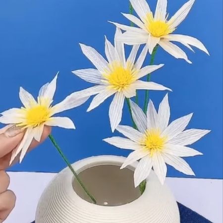 Eine Vase mit kunstvoll gestalteten Papierblumen