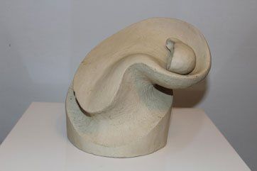 Eine abstrakte cremefarbene Skulptur mit geschwungenen Linien und weichen Konturen