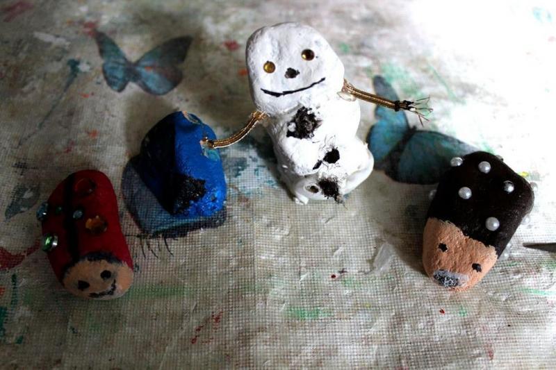 Ein Schneemann aus weißem Ton mit lächelndem Gesicht und bunten Tierfiguren