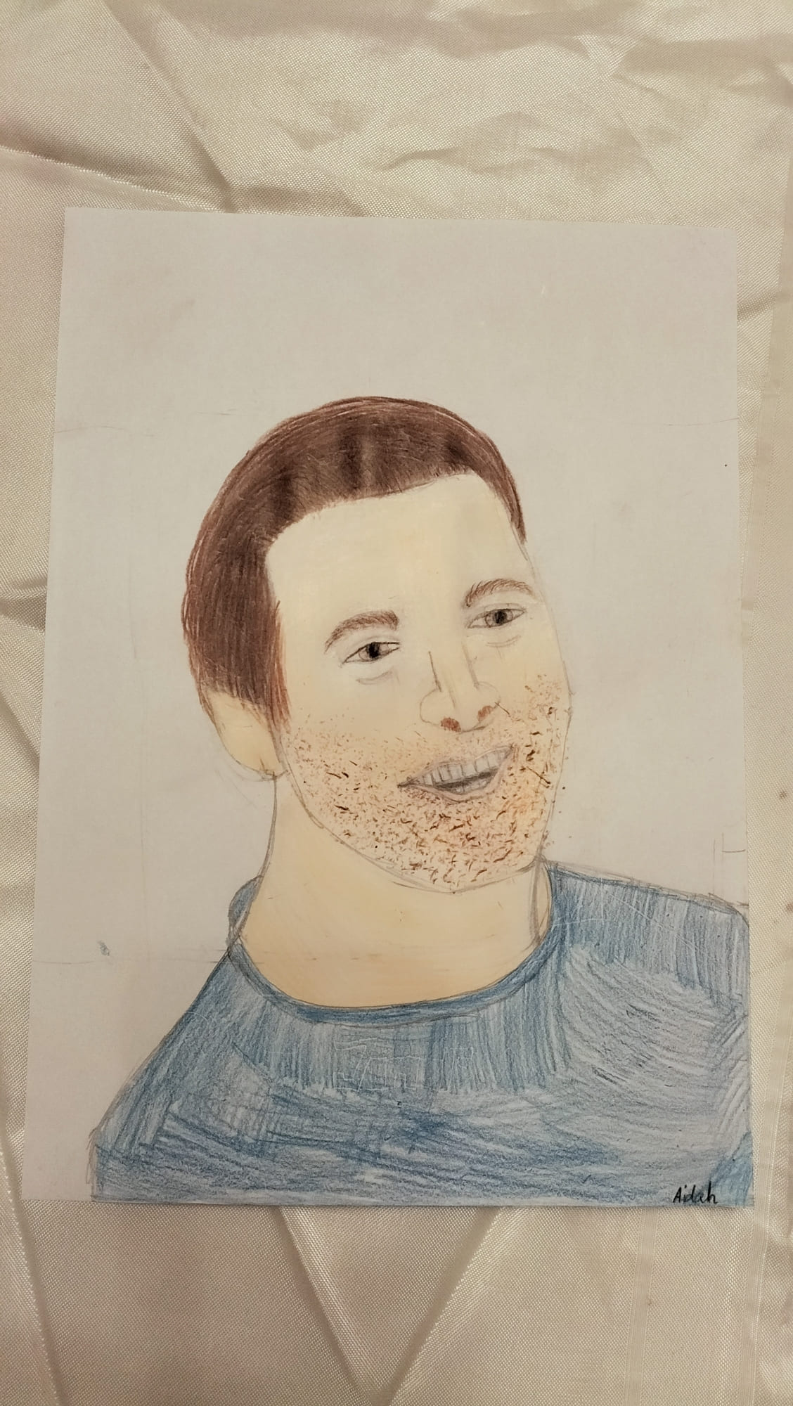 Gezeichnetes Portraet eines laechelnden Mannes mit braunem Haar im blauen Shirt